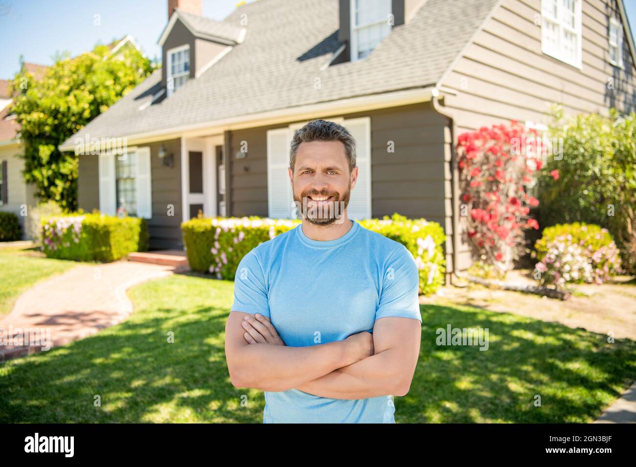 stupito unshaven ragazzo attraversato le mani vicino casa, realtor Foto Stock