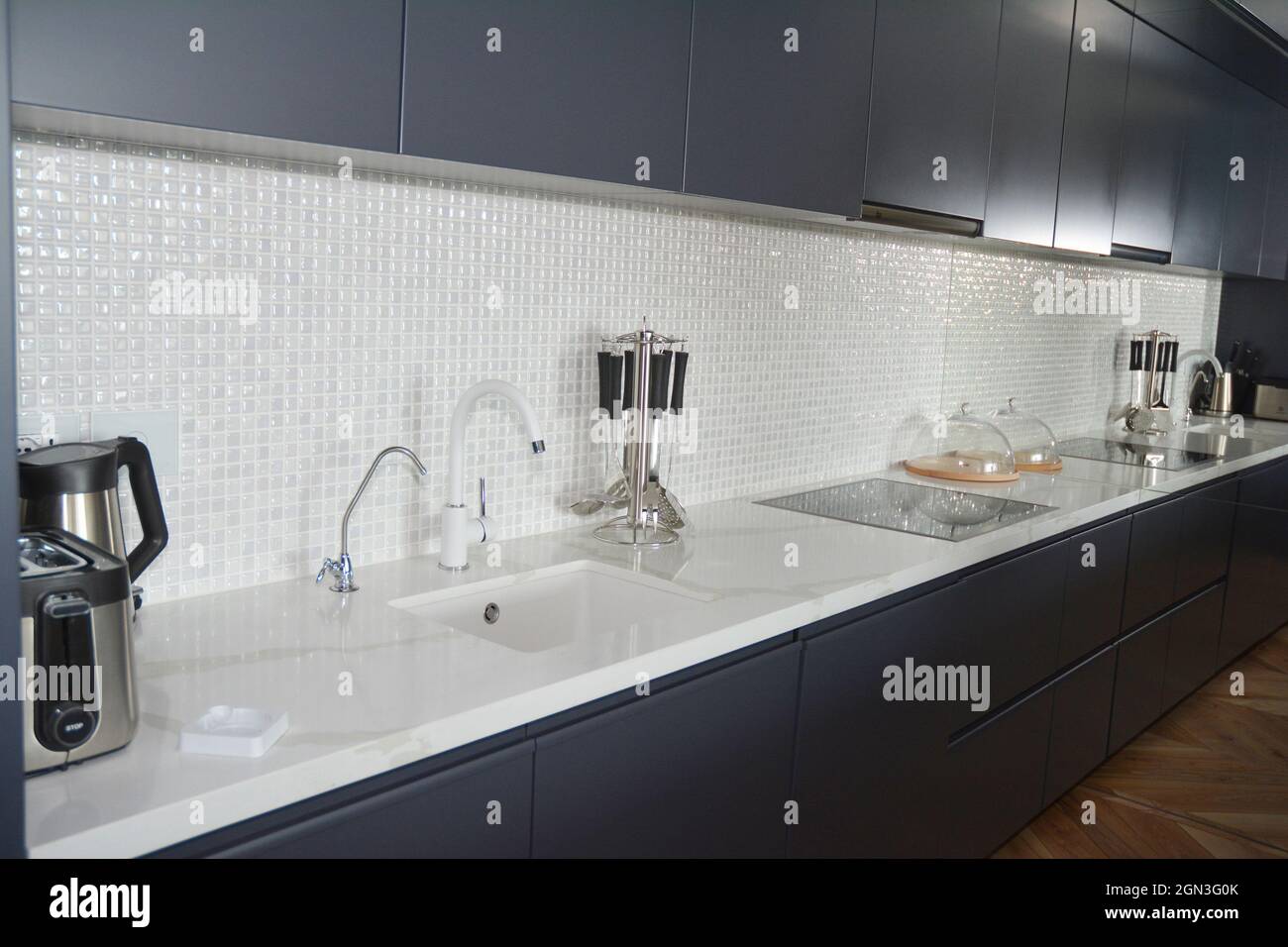 Cucina moderna con piastrelle a mosaico, rubinetto, cappa da cucina,  specchio, forno Foto stock - Alamy