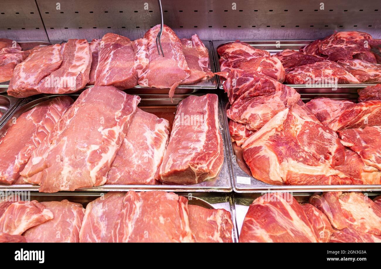 Carni fresche grezze tagliate pronte per la vendita nel mercato agricolo locale Foto Stock