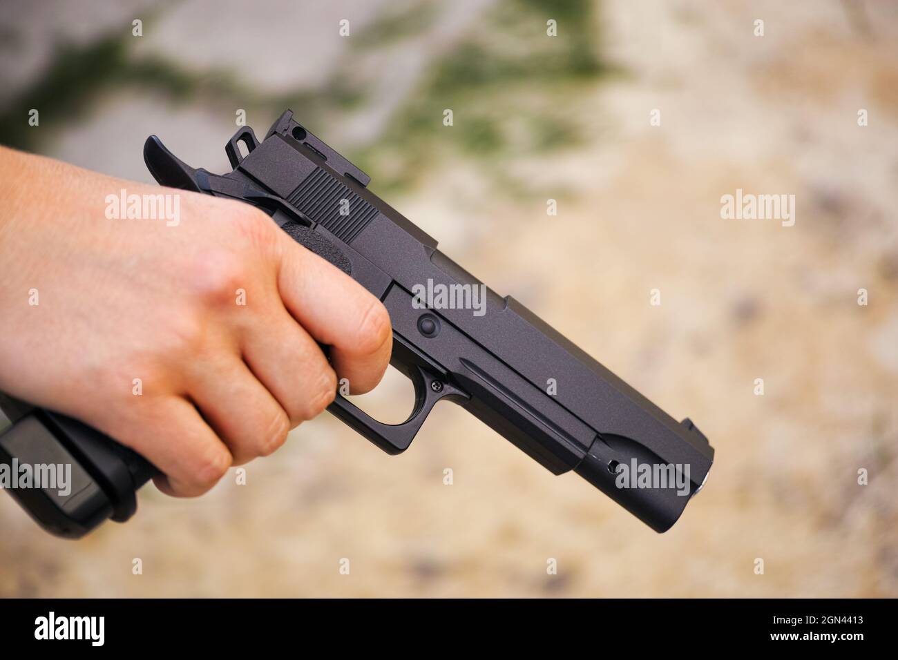 Pistola ad aria compressa nera realistica in mano di persona. Primo piano  Foto stock - Alamy