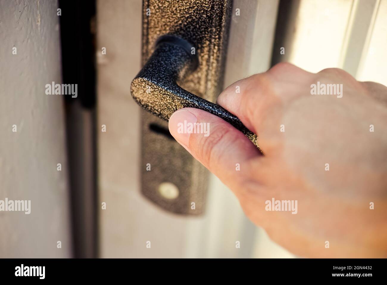 Una persona che apre una porta d'ingresso con un pomello Foto Stock