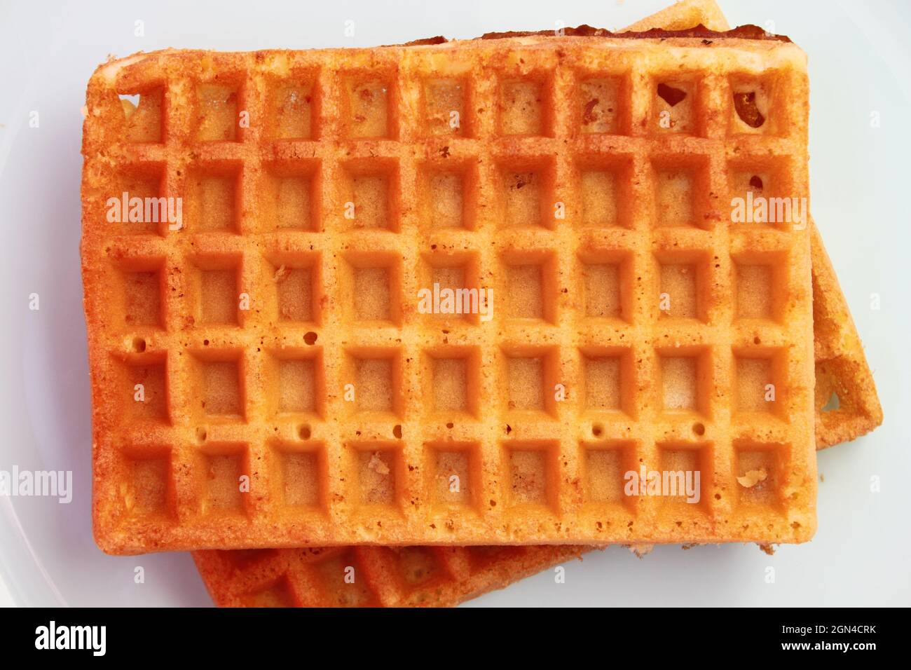 Waffle belgi con marmellata di albicocche su sfondo bianco Foto Stock