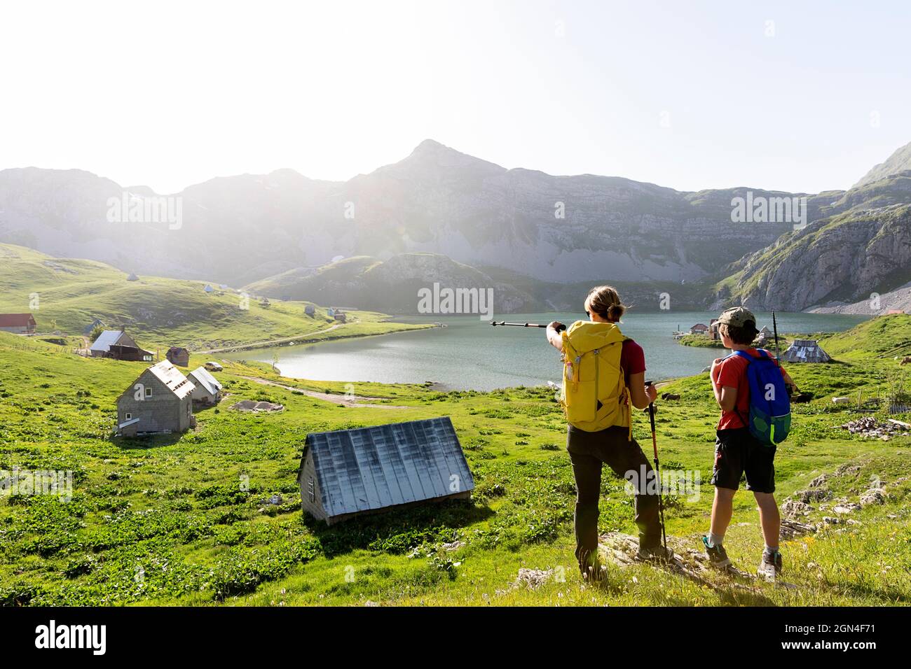 Madre e figlio escursionisti in piedi vicino a case pastorelli tradizionali sul lago Kapetanovo, il lago del capitano, nelle montagne sopra il Montenegro niksic Foto Stock