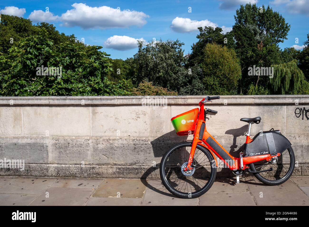Bicicletta elettrica in calce a noleggio, presso un parco a Westminster, Londra. Noleggio biciclette pubblico nella città di Londra. Bici isolata e solitaria contro il muro Foto Stock