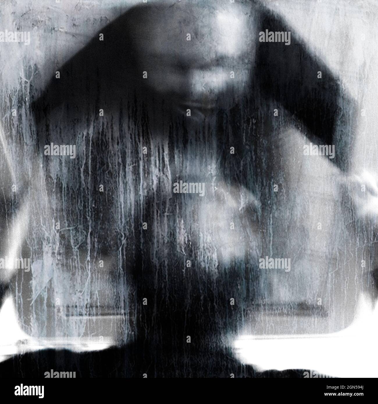 Scena horror con un volto scricchiolante nello specchio. Ritratto surreale. Esposizione prolungata. Foto Stock