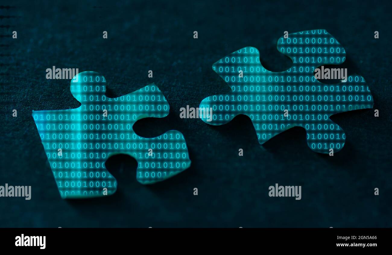 Codice binario su due pezzi di puzzle su sfondo nero Foto Stock