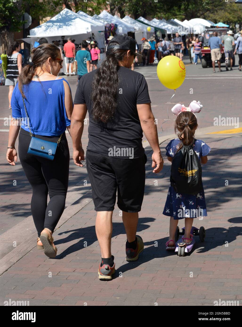 Una coppia e la loro giovane figlia visitano l'annuale Fiesta de Santa Fe a Santa Fe, New Mexico. Foto Stock