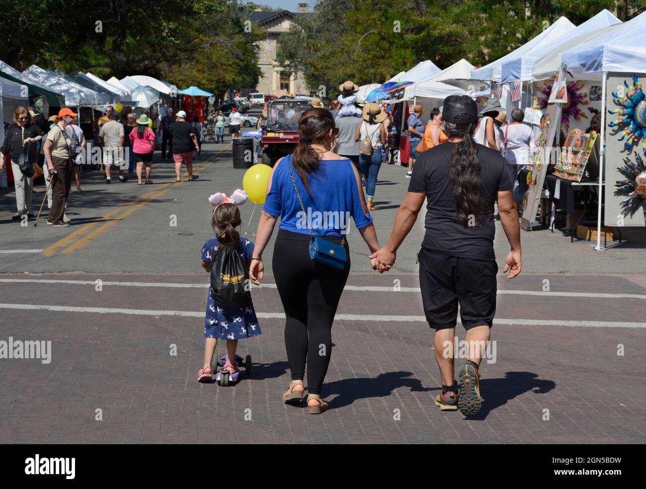 Una coppia tiene le mani mentre camminano con la loro figlia giovane all'annuale Fiesta de Santa Fe a Santa Fe, nuovo exico. Foto Stock