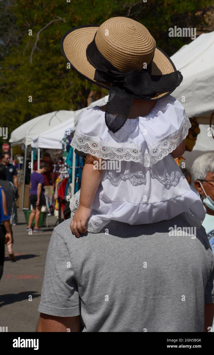 Un uomo porta la sua giovane figlia sugli urlatori mentre visitano l'annuale Fiesta de Santa Fe a Santa Fe, New Mexico. Foto Stock