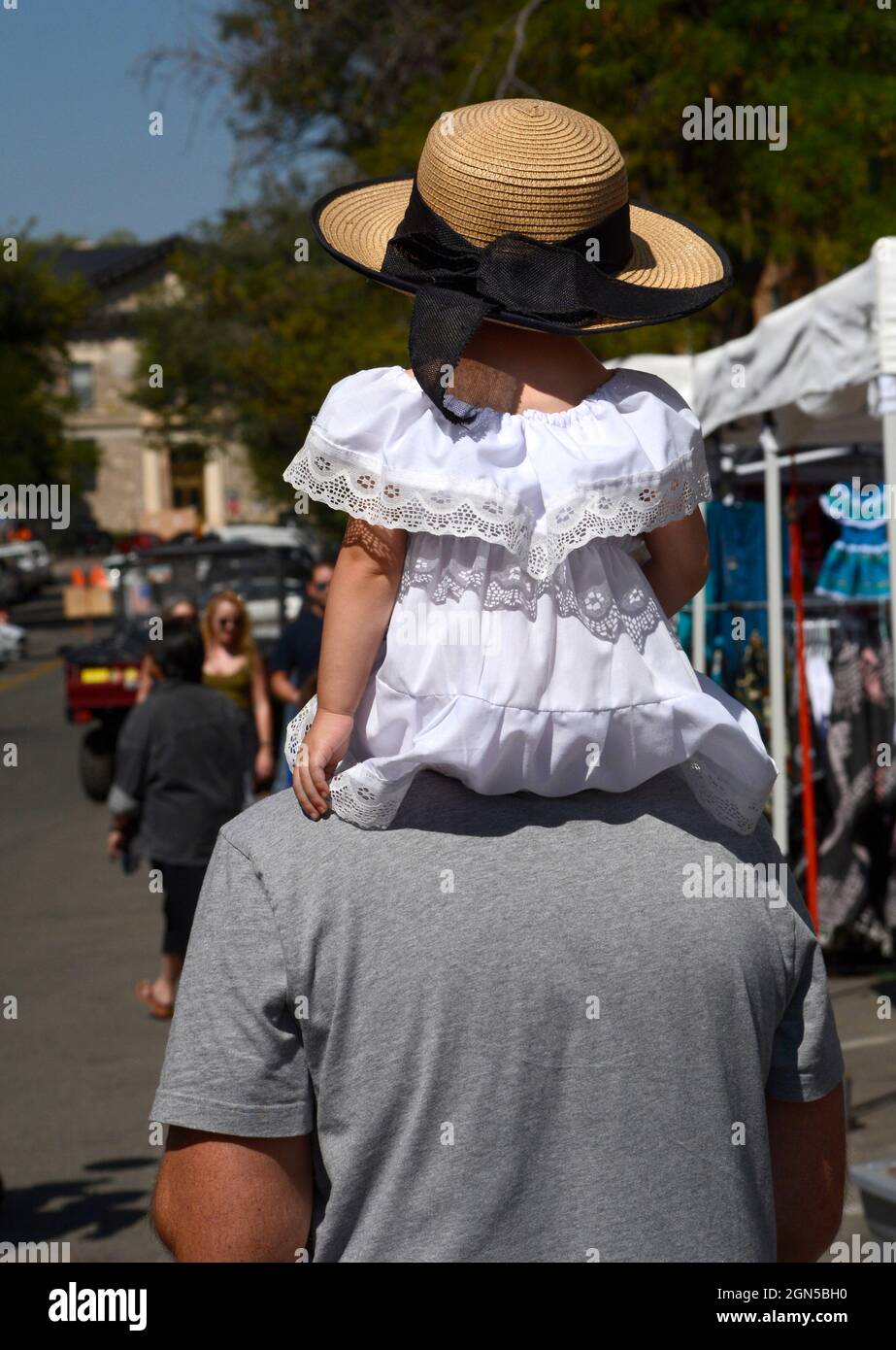 Un uomo porta la sua giovane figlia sugli urlatori mentre visitano l'annuale Fiesta de Santa Fe a Santa Fe, New Mexico. Foto Stock
