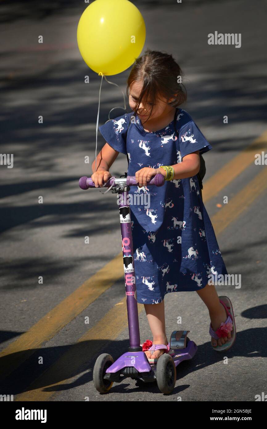 Una giovane ragazza guida lo scooter del suo bambino al festival annuale di Fiesta de Santa Fe a Santa Fe, New Mexico. Foto Stock