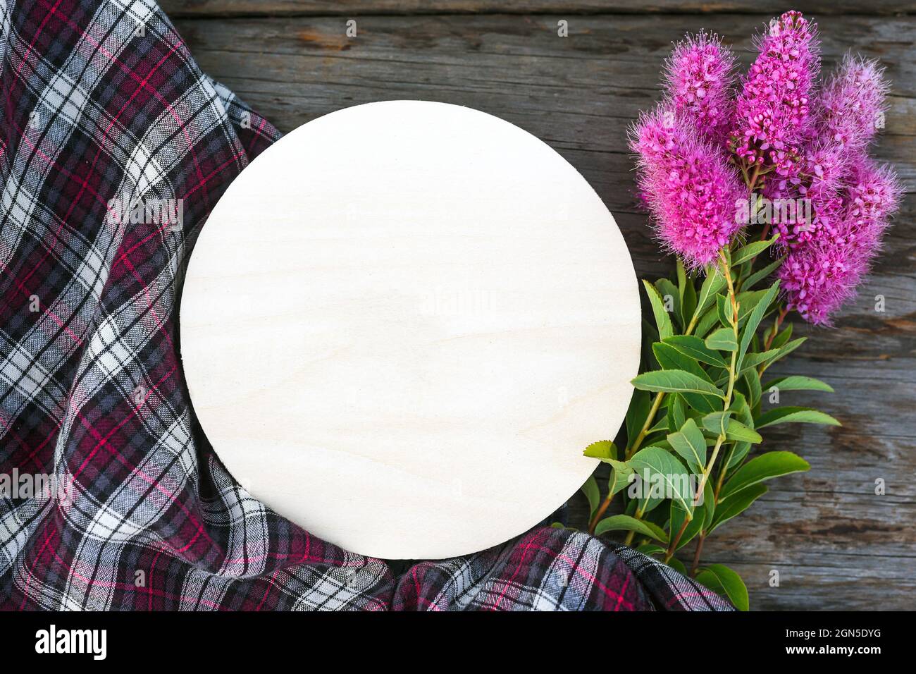 Tondeggiante segno bianco carta fiori rosa e tessuto scacchi su tavola di legno Foto Stock