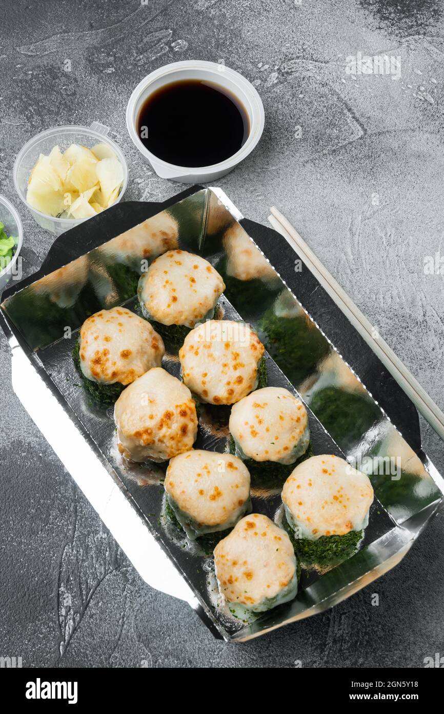 Take away sushi rotoli in contenitori, philadelphia rotoli e gamberi cotti set, su sfondo di pietra grigia Foto Stock