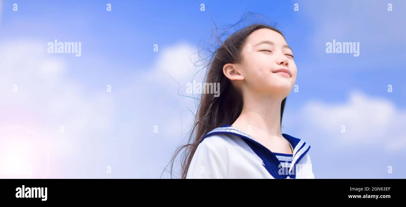 Bella studentessa che gode la brezza estiva, sorridente con gli occhi chiusi Foto Stock