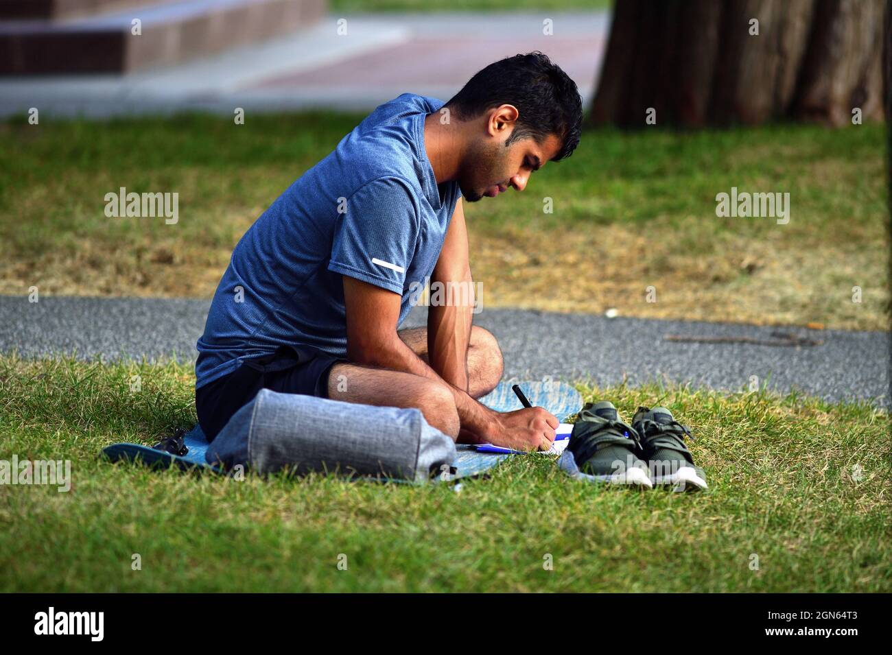 Chicago, Illinois, Stati Uniti. Uomo che registra le informazioni in un notebook mentre si rilassa in un parco vicino a Navy Pier. Foto Stock