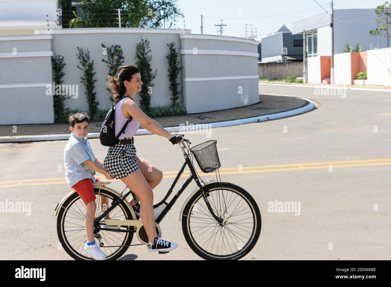 Madre e figlio brasiliani in bicicletta in una mattinata di sole. Foto Stock