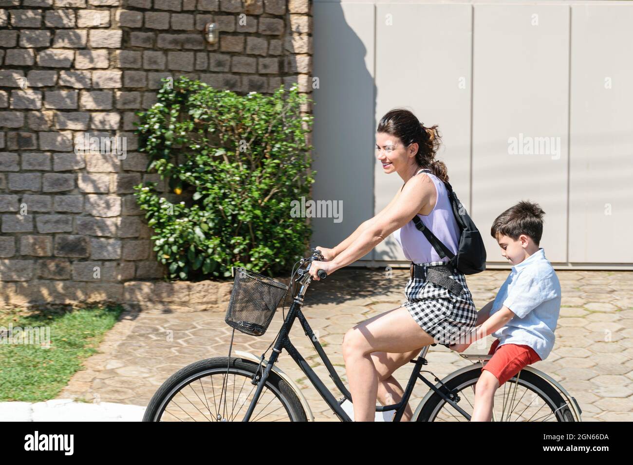 Madre e figlio brasiliani rilassarsi e andare in bicicletta in una mattinata di sole. Foto Stock