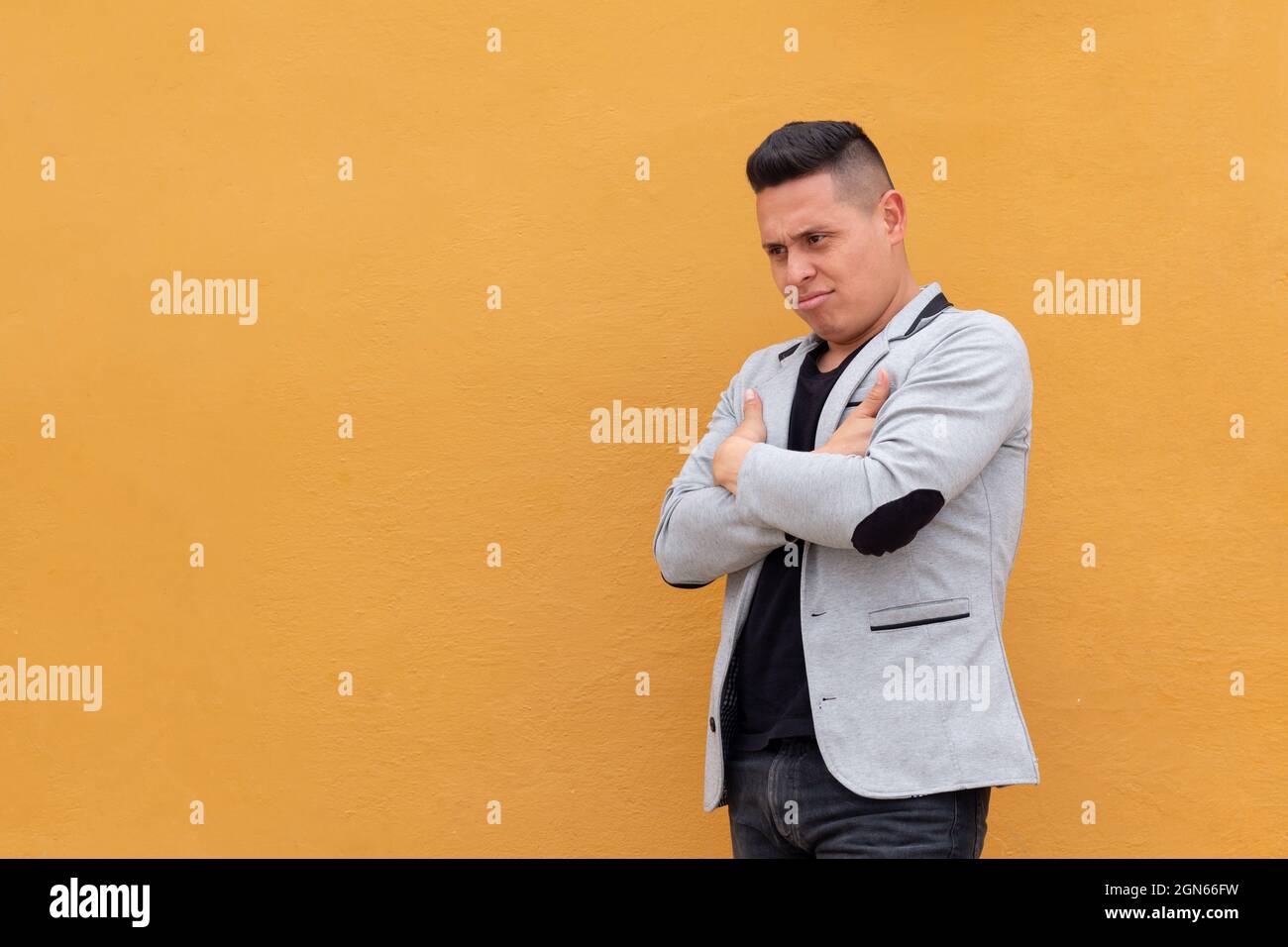 Uomo confuso o incredulo. Espressioni su una singola parete colorata Foto Stock