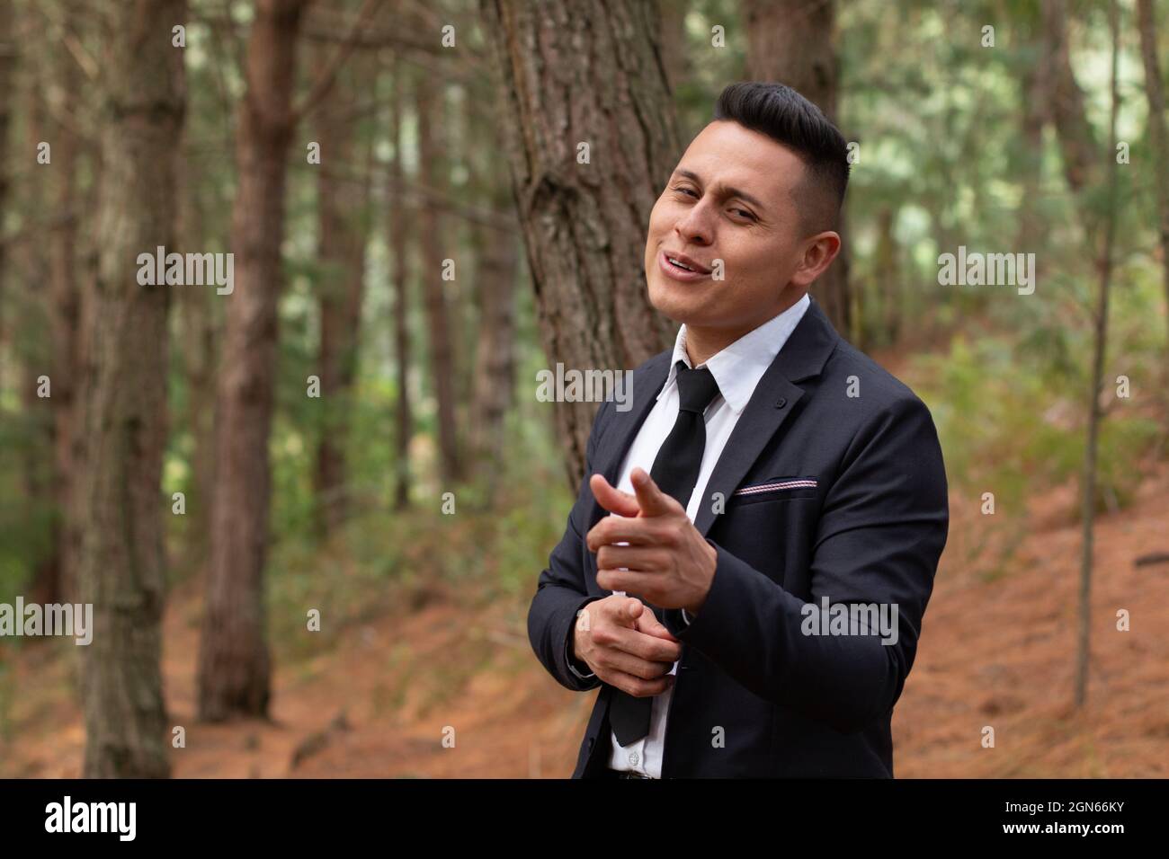 Uomo in una foresta arancione che canta e punta di fronte. Foto Stock