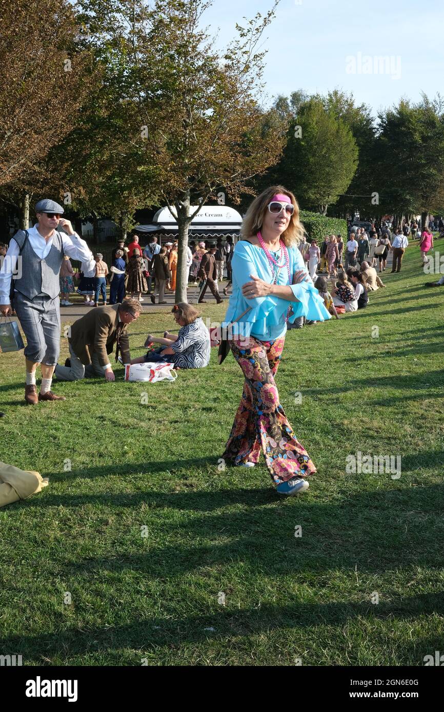 Settembre 2021 - Donna gara goer in costume hippy, top luminoso e pantaloni svasati, al Goodwood Revival Foto Stock