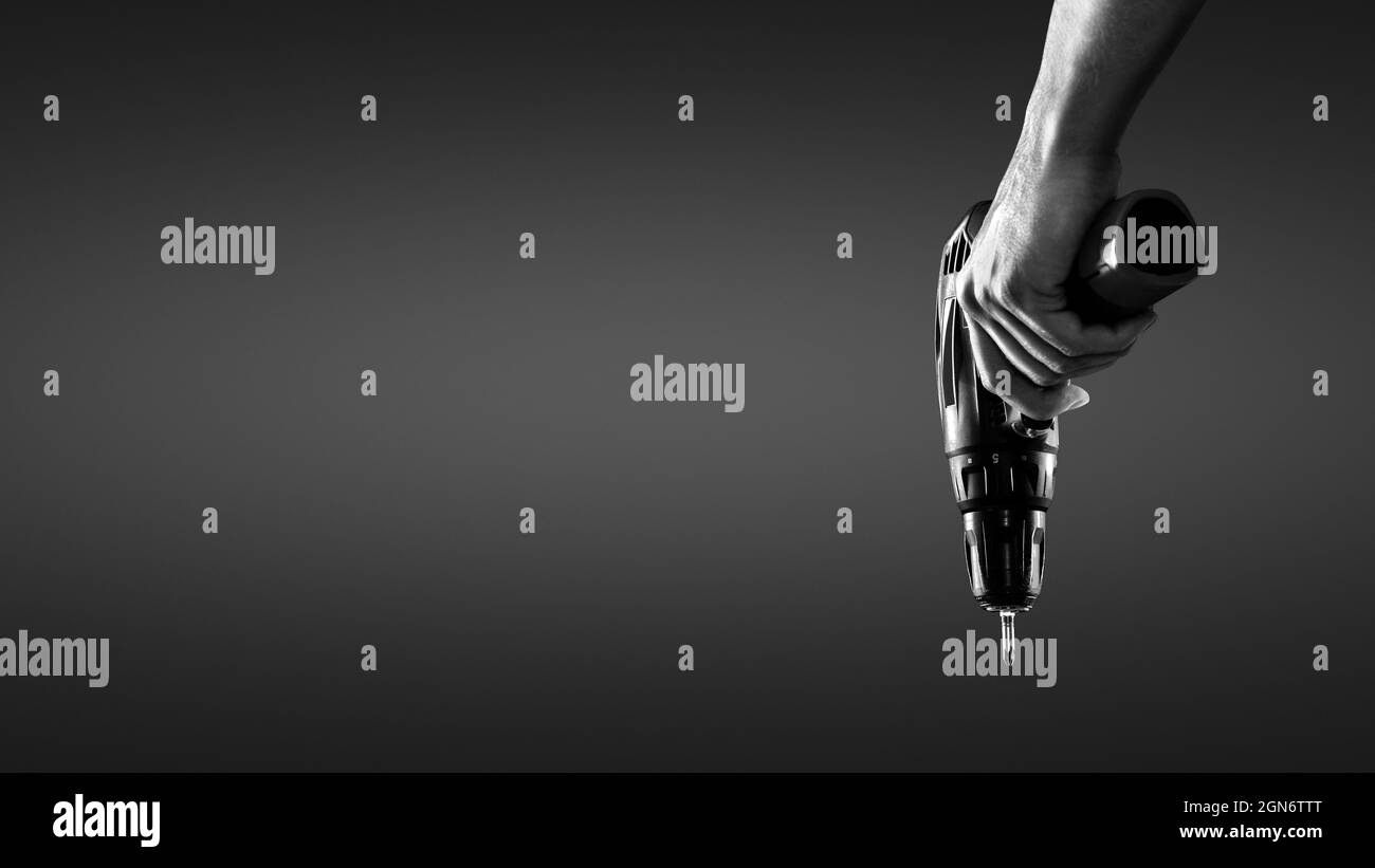 Tenere a mano un cacciavite a batteria Foto Stock