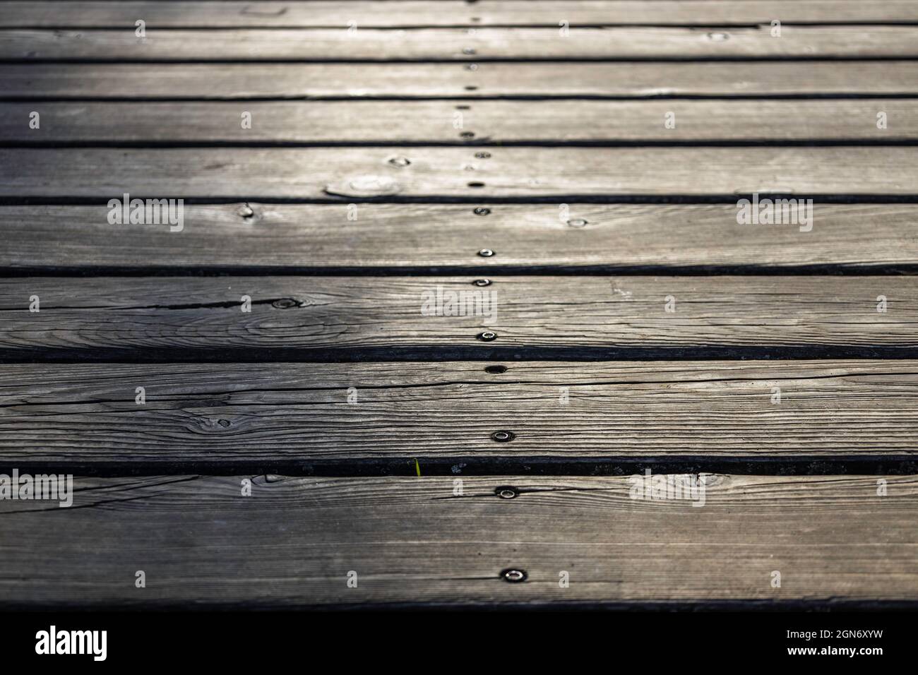 Sfondo vecchio pavimento in legno grigio fatto di plane e fori profondi Foto Stock