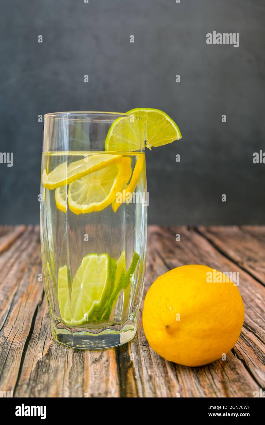 Una bevanda estiva sana e rinvigorente a base di succo di limone e lime con spicchi di agrumi Foto Stock