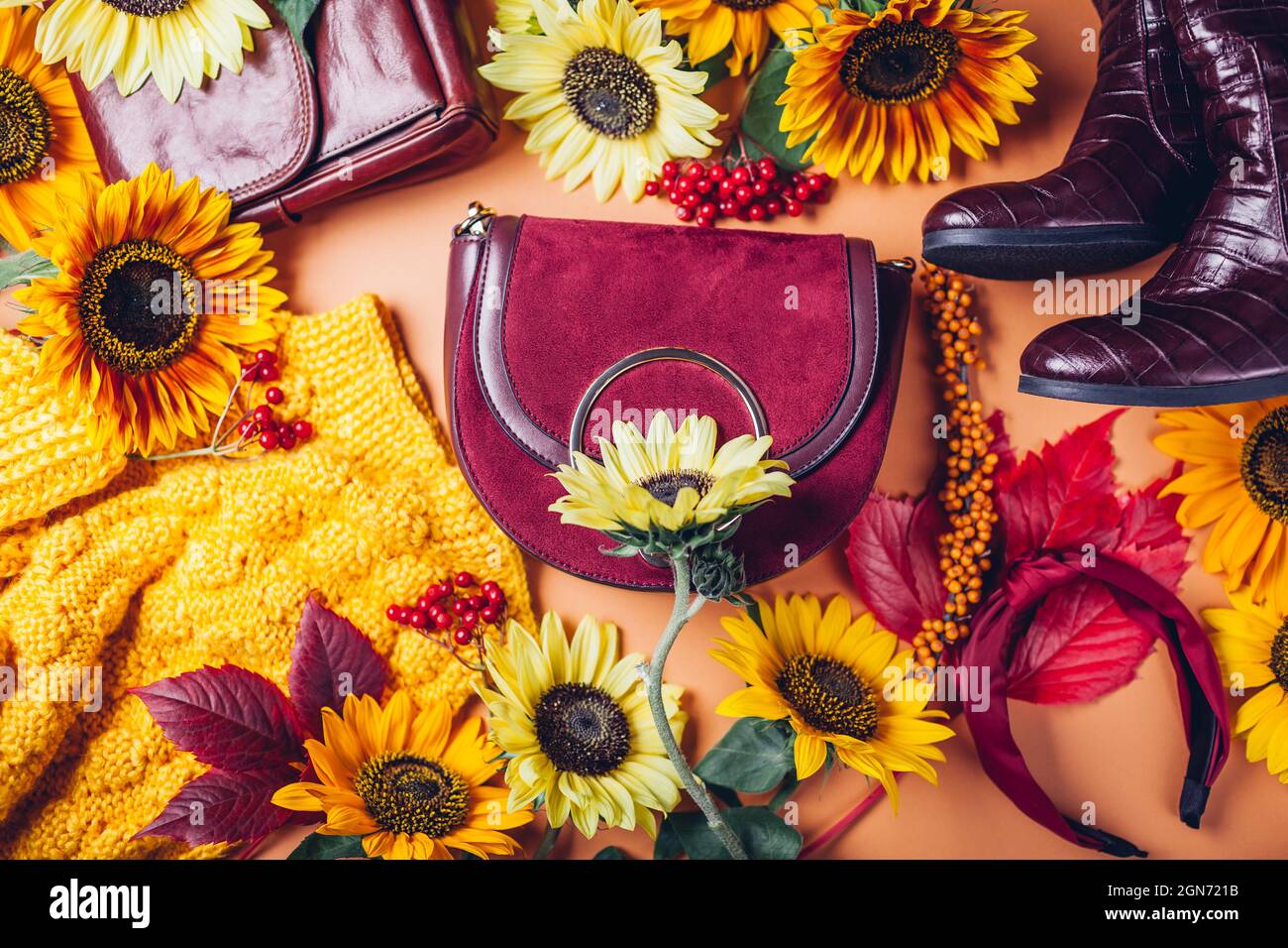 Vista dall'alto della moda femminile autunnale in colore rosso giallo arancio con fiori. Abbigliamento scarpe accessori. Foto Stock