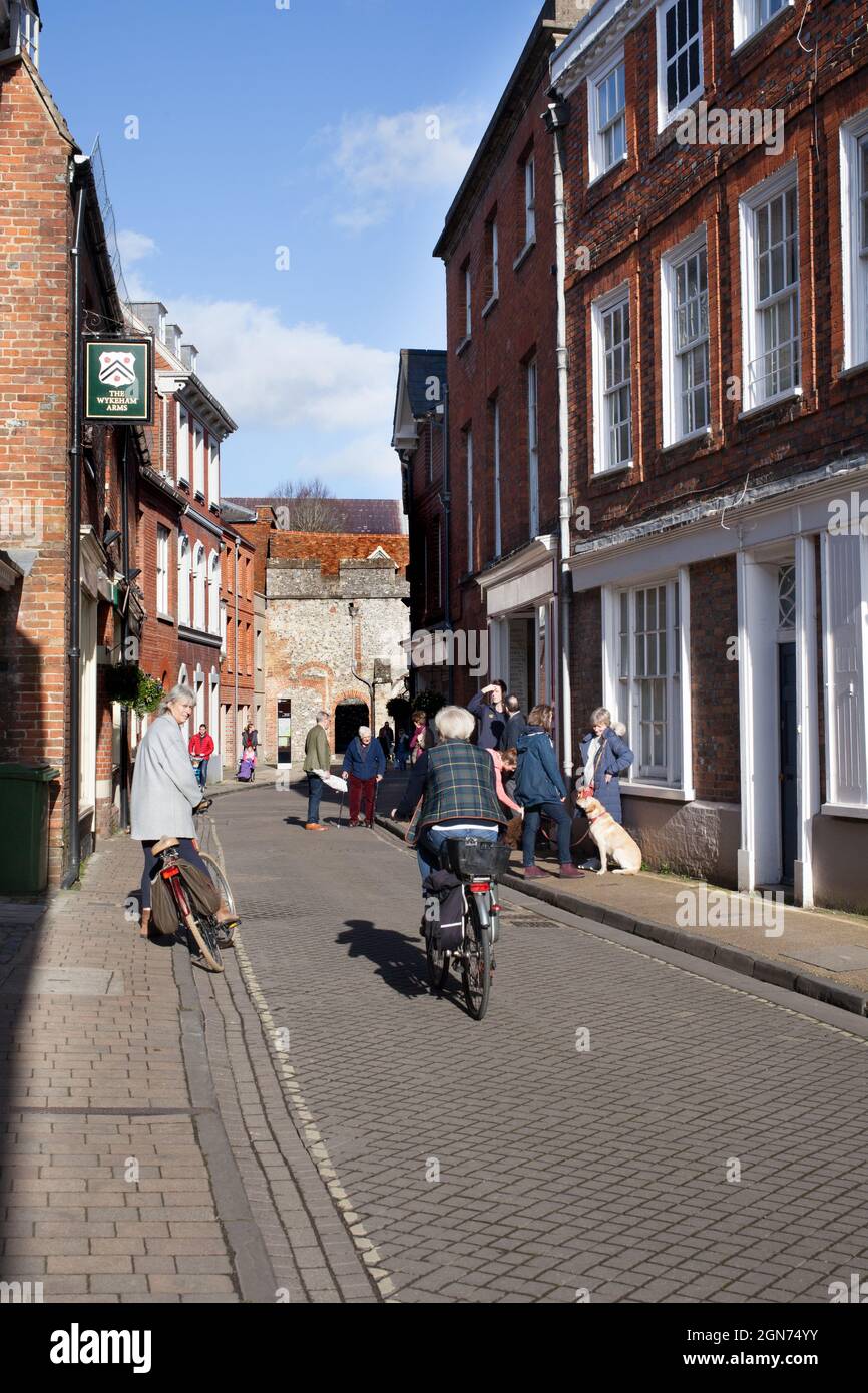 Una gente che pedala e parla l'un l'altro su una strada laterale residenziale a Winchester nel Regno Unito Foto Stock
