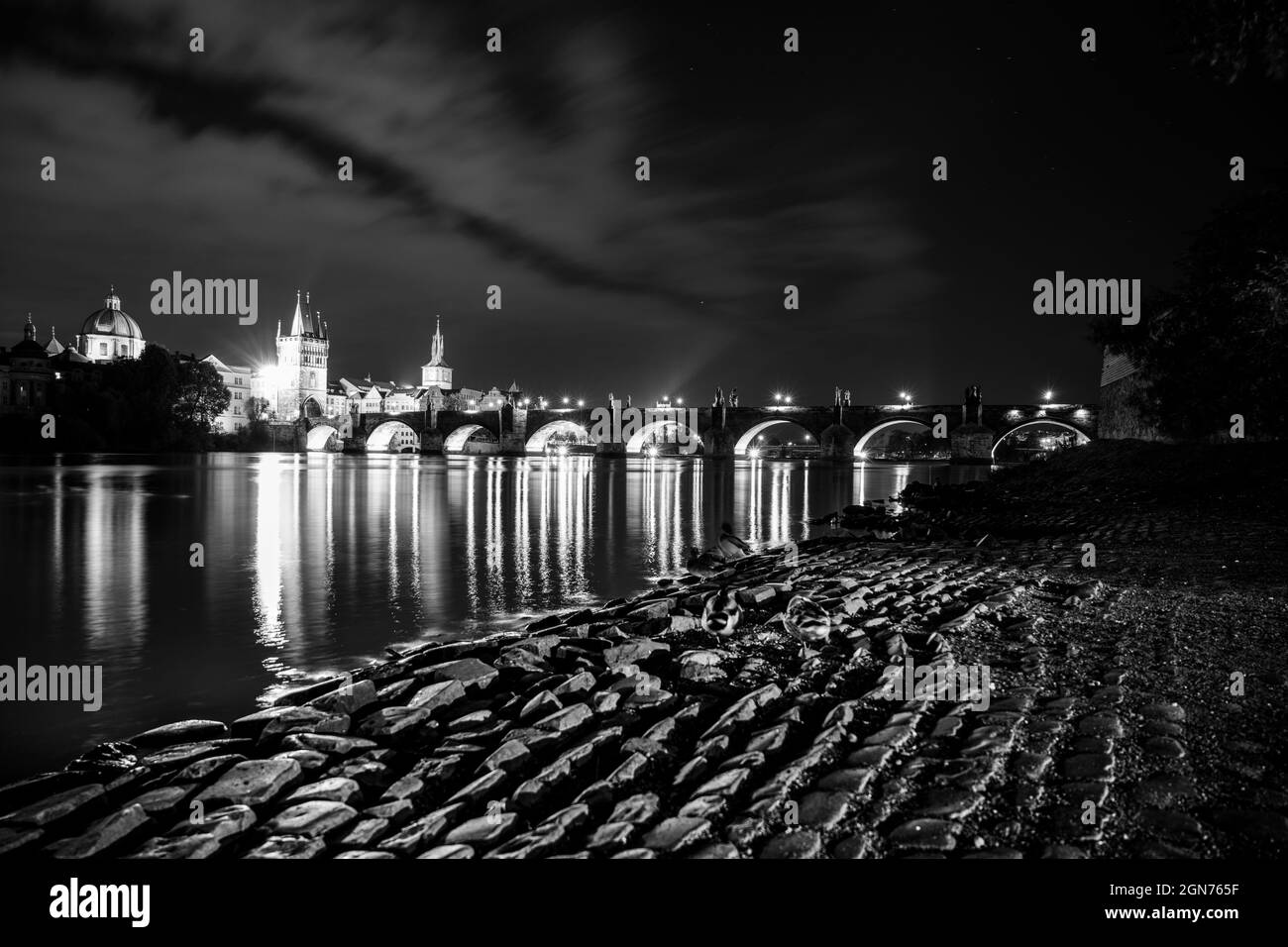 Ponte Carlo e fiume Moldava di notte. Praga, Repubblica Ceca. Immagine in bianco e nero. Foto Stock