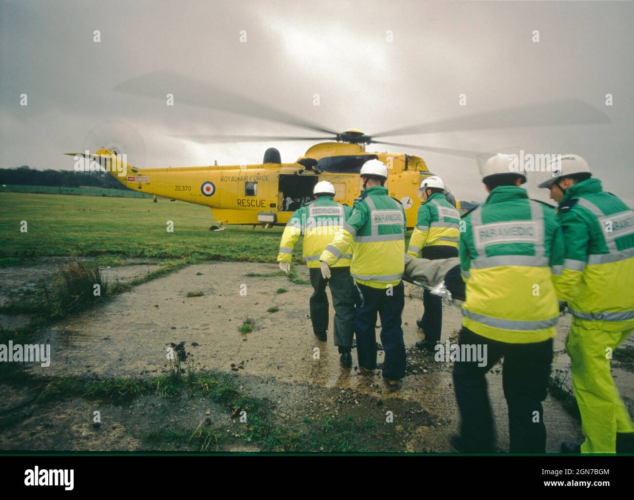 Paramedici barella un passeggero simulato ferito a un elicottero in attesa durante un esercizio di difesa civile. Foto Stock