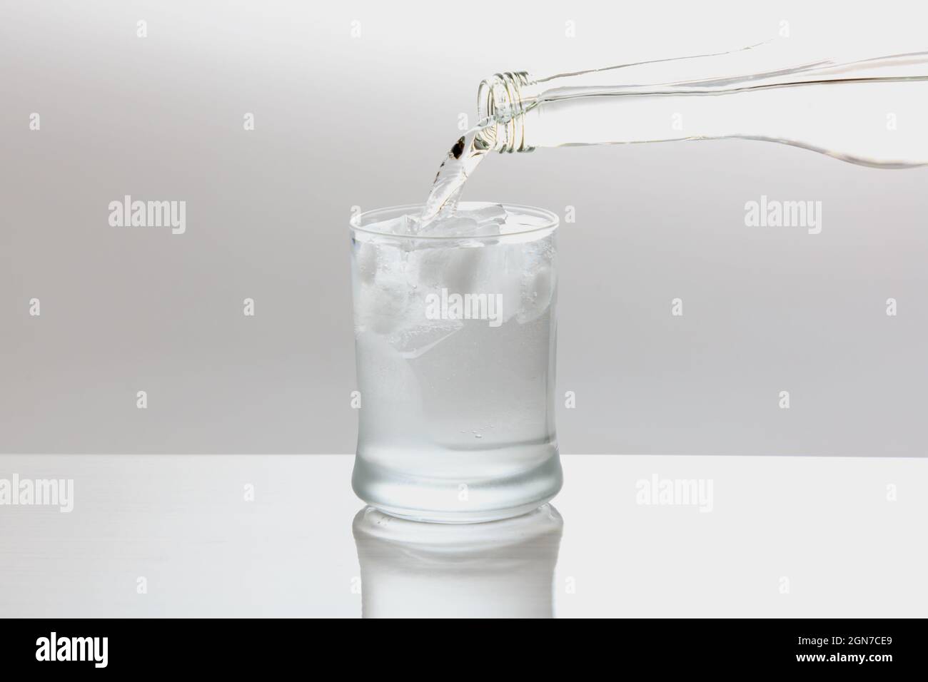 Versare acqua in un bicchiere di vetro Foto Stock