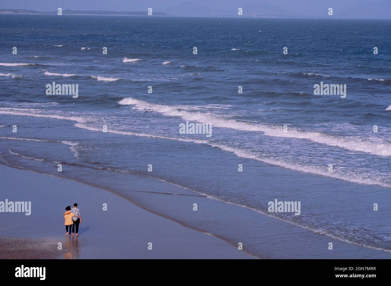 Vietnam. Vung Tao. Spiaggia Bai Sau. Giovane coppia fuori a piedi. Foto Stock