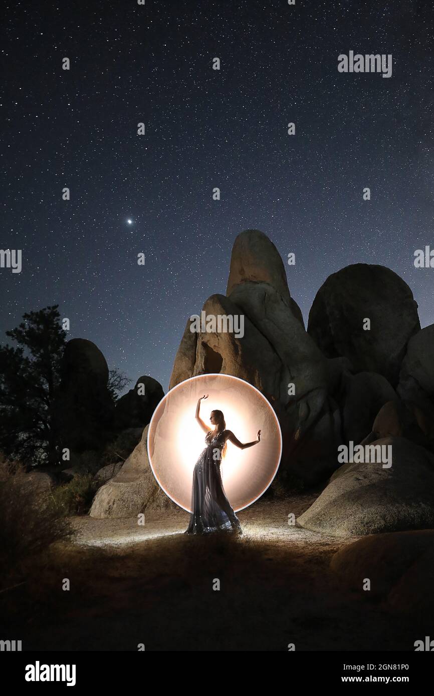 Modello dipinto di luce in posa con stelle nel deserto Foto Stock