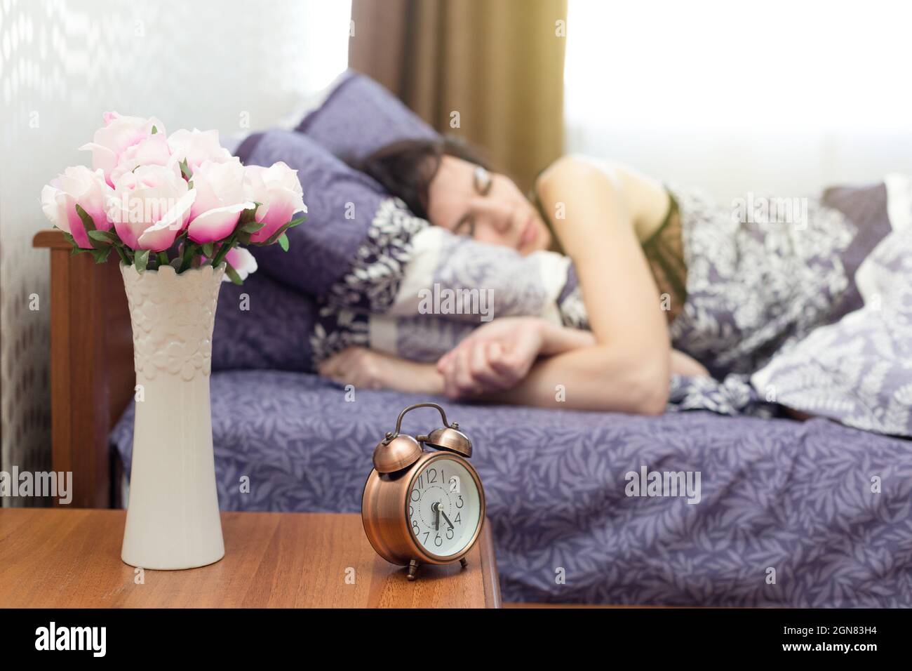 Il suono di una sveglia forte non può svegliare una donna che è addormentato veloce. Foto Stock
