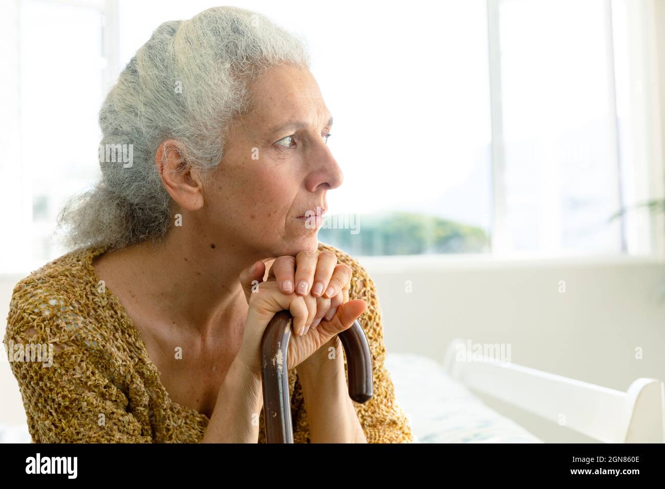Profilo della donna causiana premurosa che tiene la verga e che guarda a distanza Foto Stock