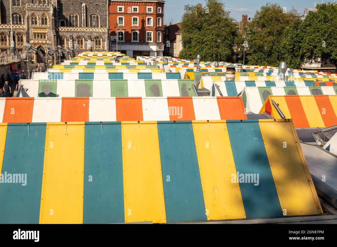 Una vista delle colorate canopie a strisce sulle bancarelle del mercato storico di Norwich in una giornata estiva Foto Stock