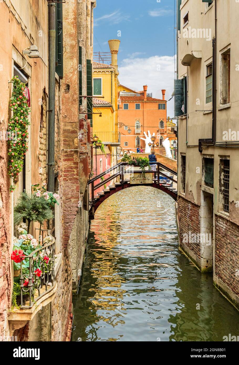 Venezia, Venezia, Italia Luglio 24 2017 canale tributario di Venezia con una passerella pedonale ad arco che guarda verso le mani aiutanti Foto Stock