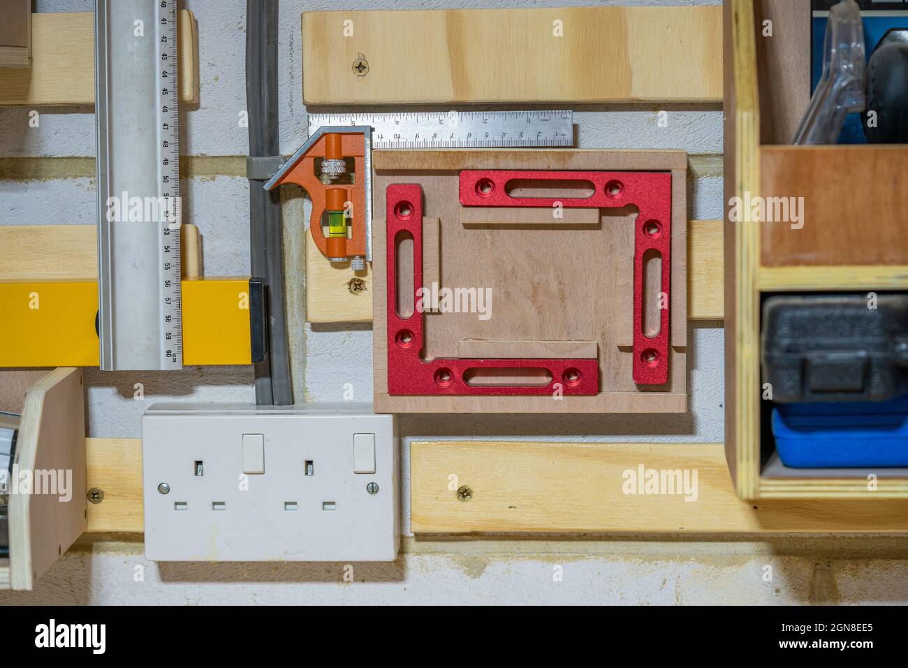 Primo piano focus selezionato di un sistema di stoccaggio utensili Cleat francese in un'officina con prese elettriche e cablaggio del Regno Unito Foto Stock