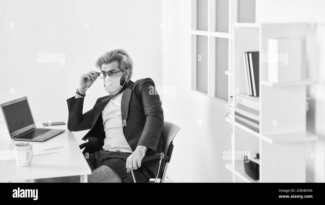 Rimani a casa. Uomo indossare maschera medica lavoro con computer portatile. Evitare il contatto con altre persone. Lavorare da casa. Online. Auto isolamento top Response tattica per Foto Stock