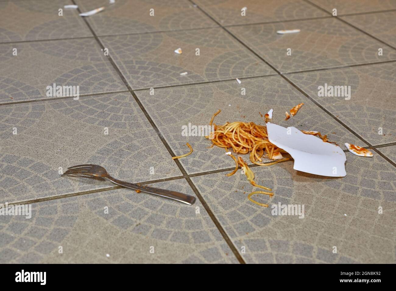 Piatto caduto di pasta nel pavimento della cucina Foto Stock