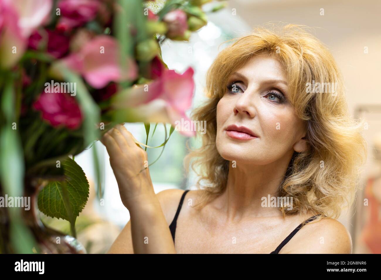 Bella donna anziana con capelli biondi in boutique Foto Stock