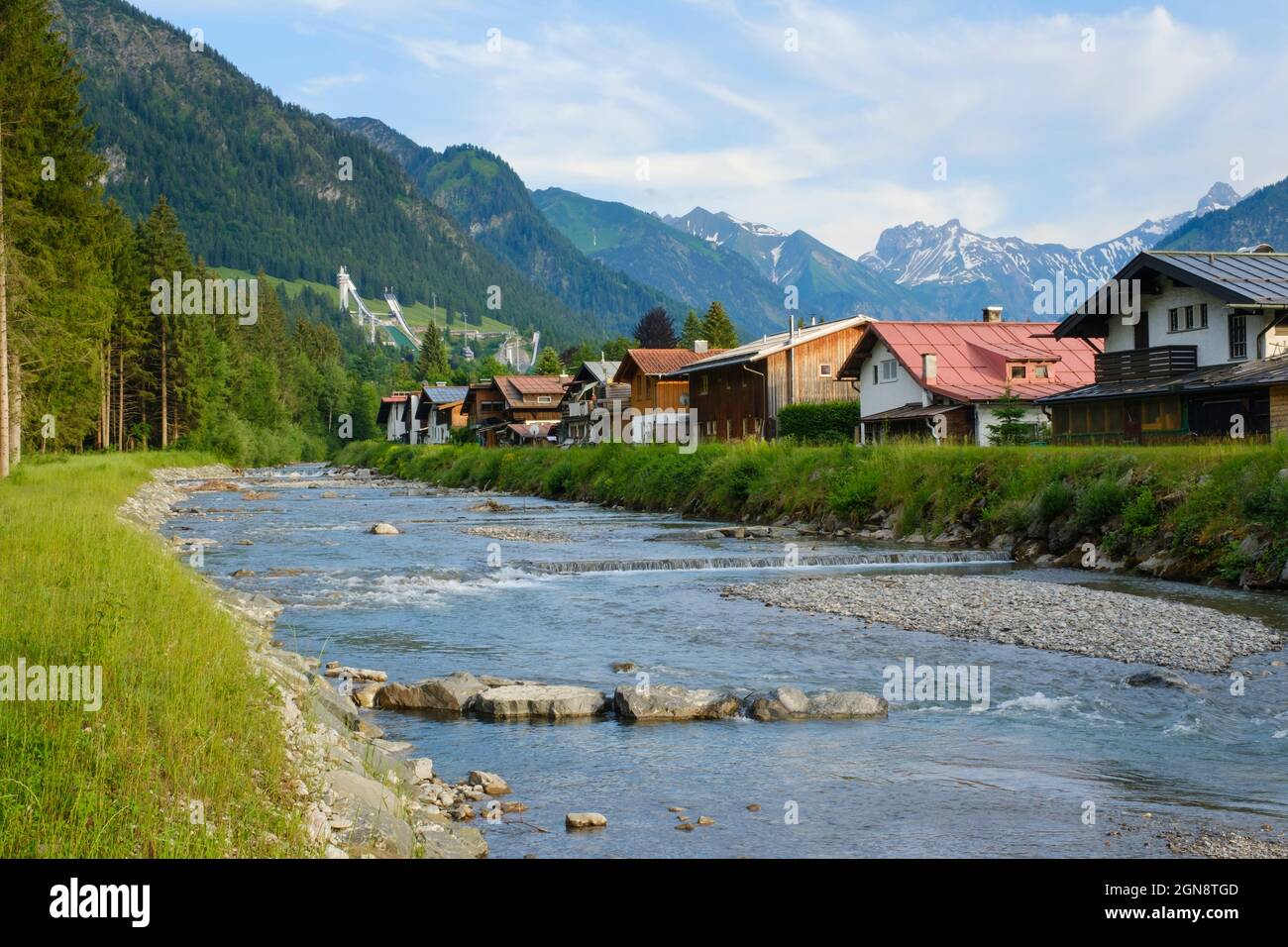 Germania, Baviera, Oberstdorf, fiume Trettach che scorre oltre città di montagna in estate Foto Stock