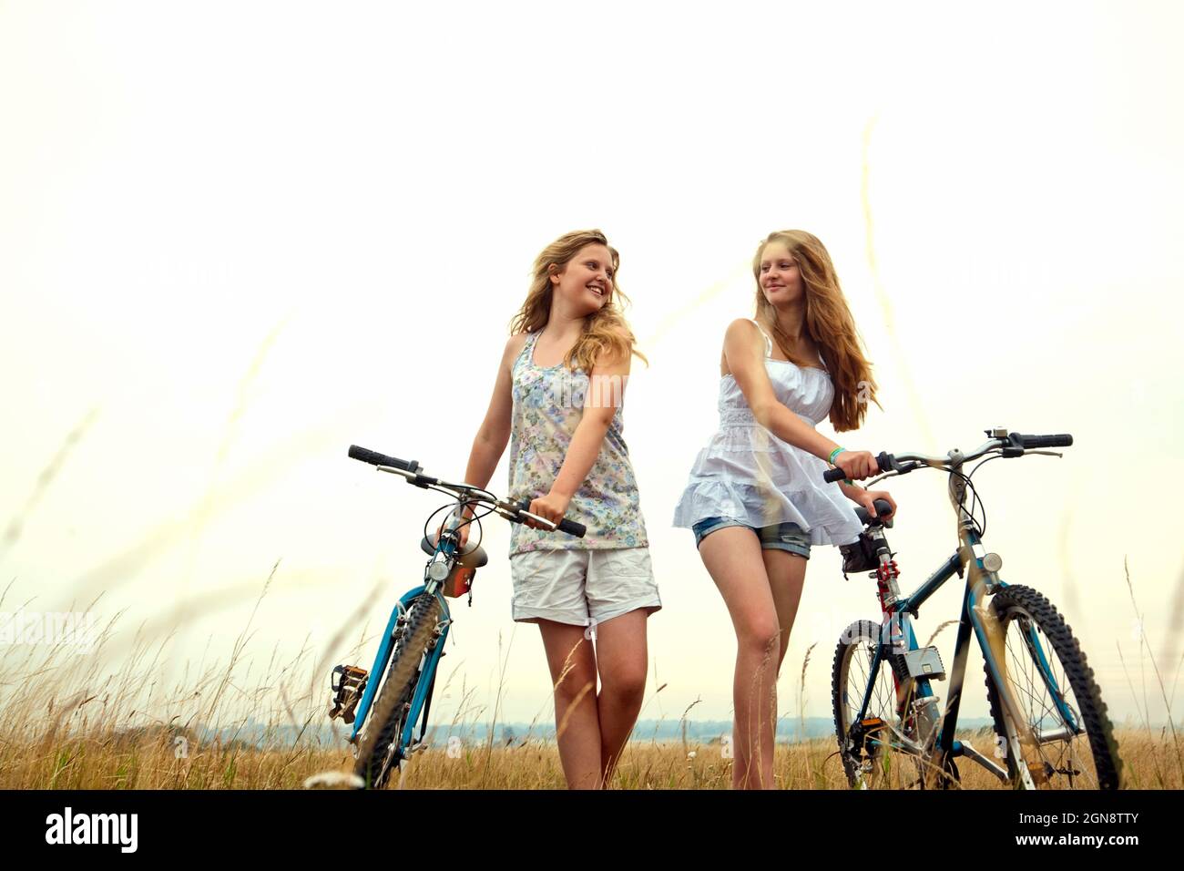Amici sorridenti che camminano in bicicletta durante le vacanze Foto Stock
