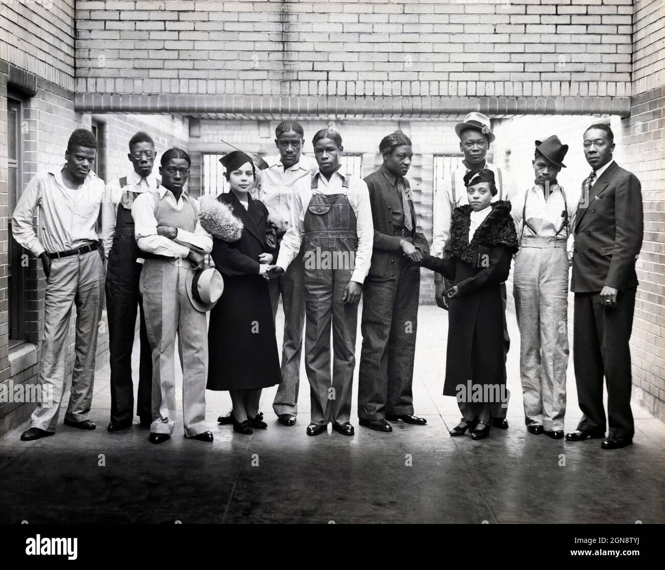 Otto dei nove Scottsboro Boys, Ozie Powell, Olen Montgomery, William Roberson, Charles Weems, Clarence Norris, Haywood Patterson, Andrew Wright e Eugene Williams, accusati falsamente di stuprare due donne bianche, con i rappresentanti del NAACP Juanita Jackson Mitchell, Laura Kellum, e Dr. Ernest W. Taggart, ritratto a tutta lunghezza all'interno della prigione, Alabama, USA, Britton & Patterson, 1936 Foto Stock