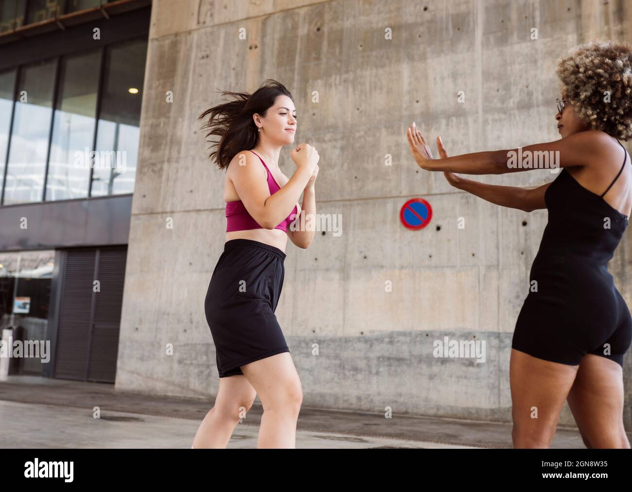 Donne medio adulte in abbigliamento sportivo praticando sport di pugilato Foto Stock