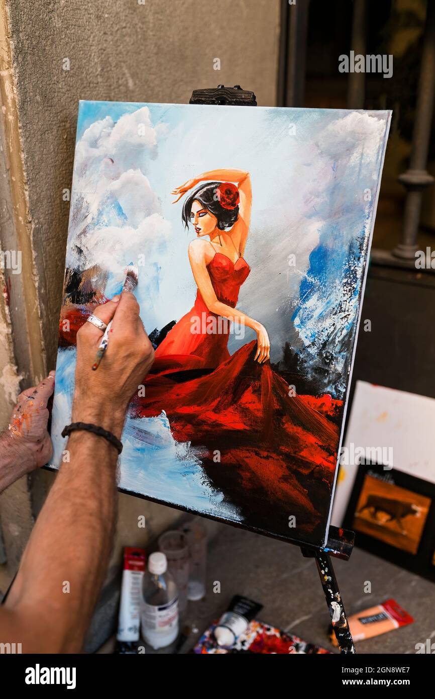 Artista di strada maschile creativo pittura femminile su tela Foto Stock