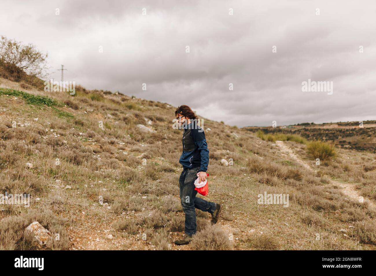 Uomo maturo che cammina con ghiande in borsa Foto Stock