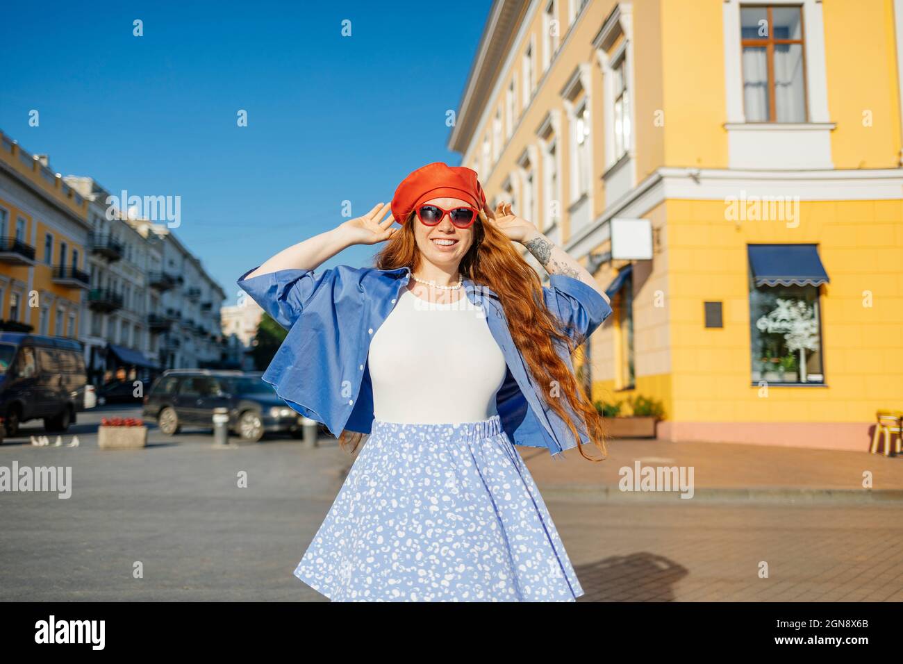 Allegra donna alla moda in piedi sul sentiero durante la giornata di sole Foto Stock