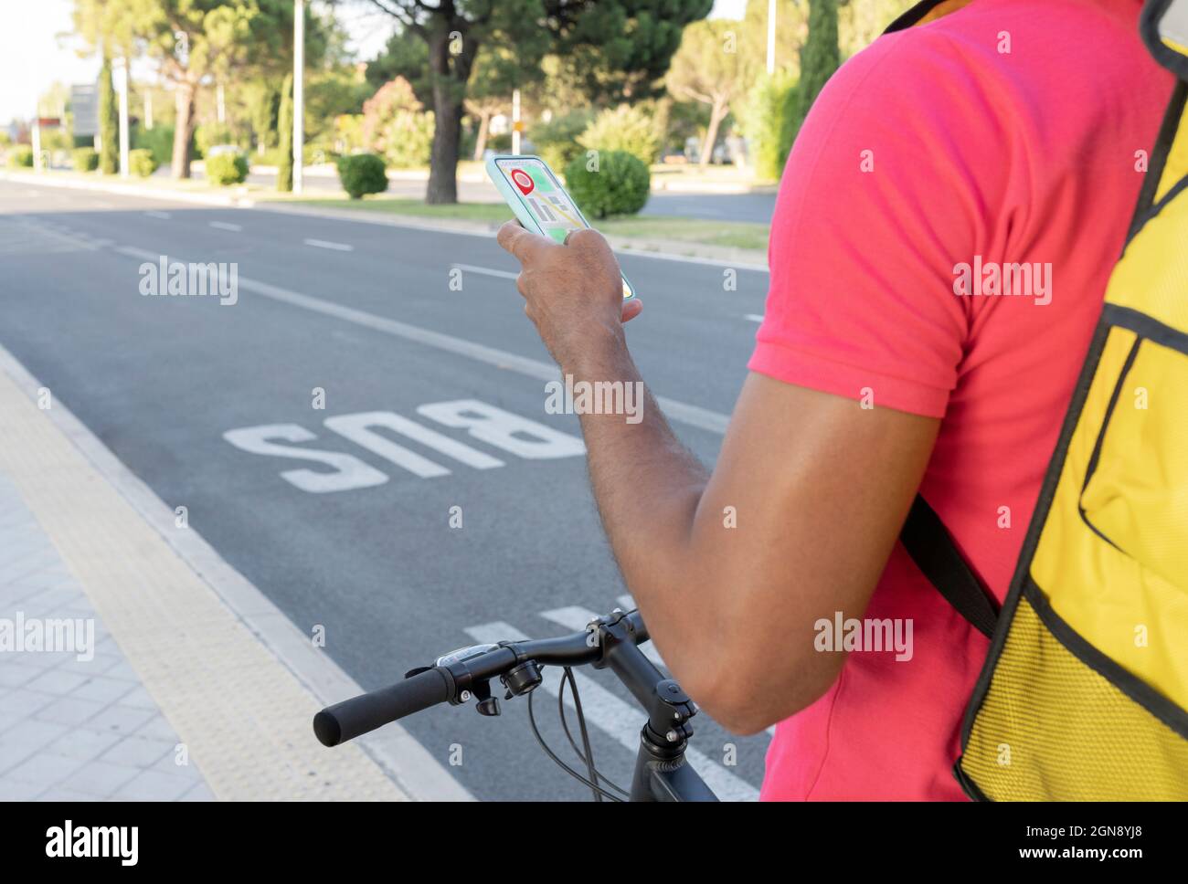 Uomo bike Messenger utilizzando l'applicazione mobile sul sentiero Foto Stock
